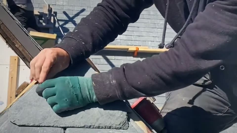 Ardoise en écailles sur une lucarne, taillée et posée à la main