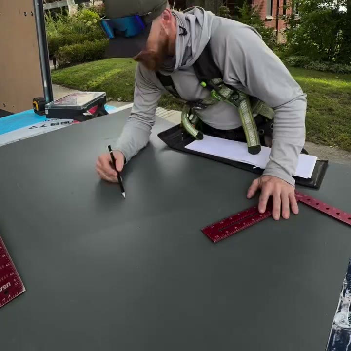 Traçage à la main d’un patron sur une feuille de zinc